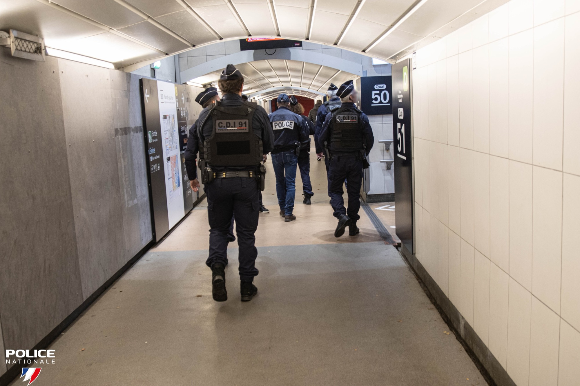Présence de l'unité dans un couloir de gare, vue de dos